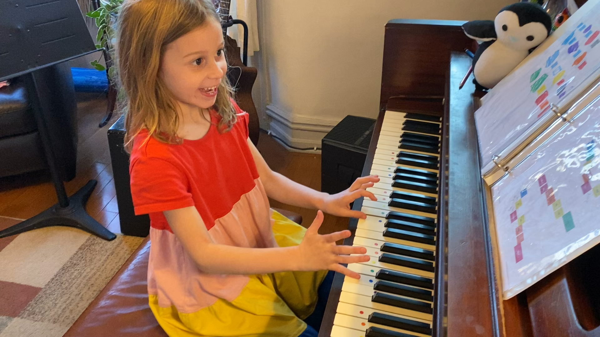 A young Musicolor Method student joyfully playing piano